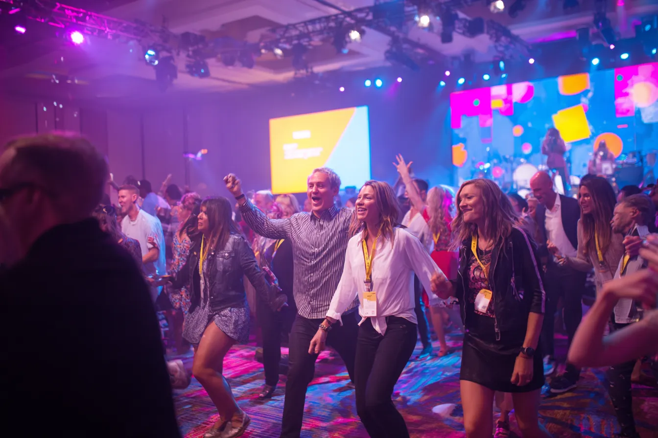 Grote gemengde groep volwassenen danst enthousiast mee met Just Dance op een corporate event