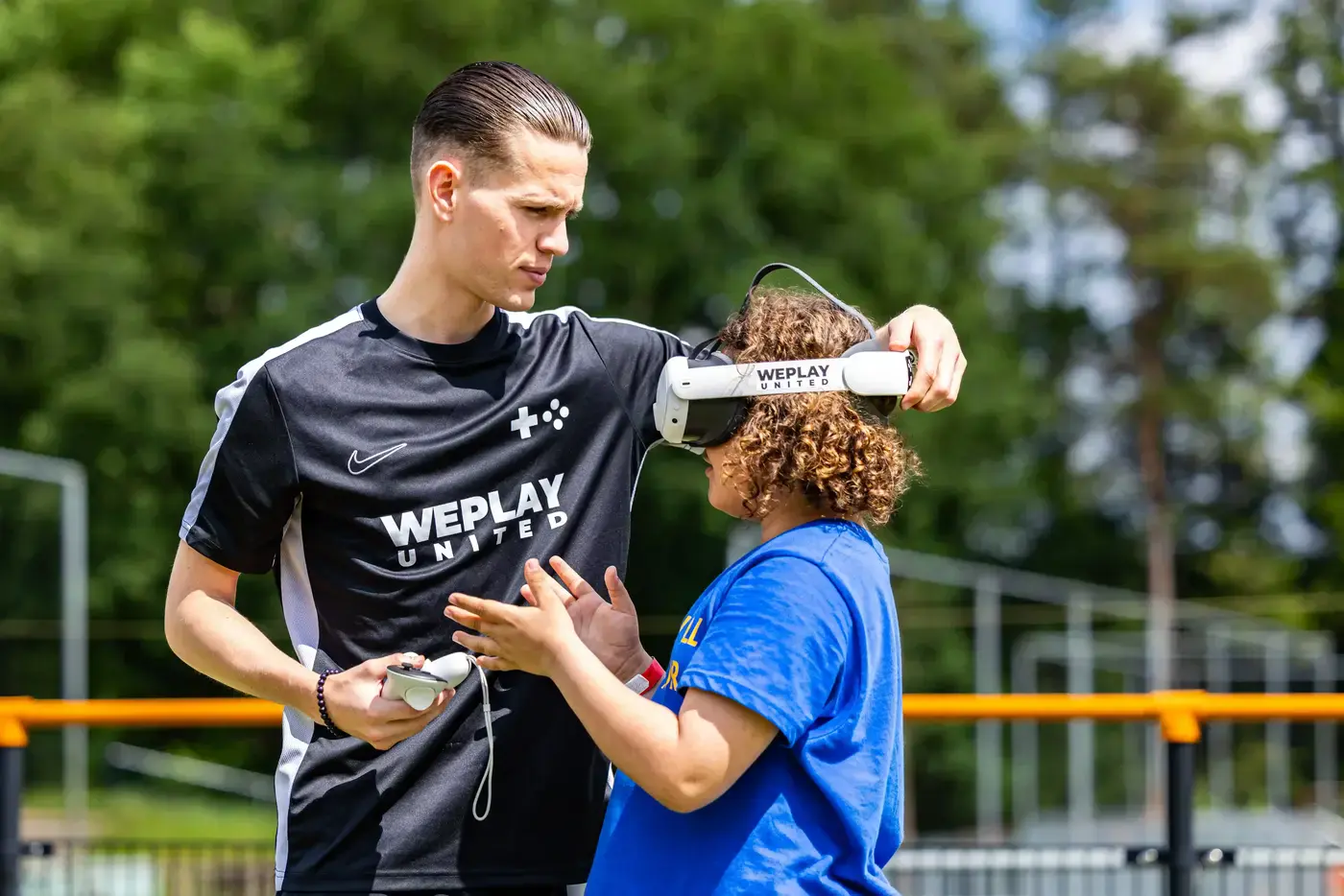 WePlay United medewerker helpt een kind met het opzetten van een VR-bril op een buitenlocatie