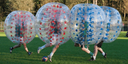 Vier mensen spelen bubbelvoetbal