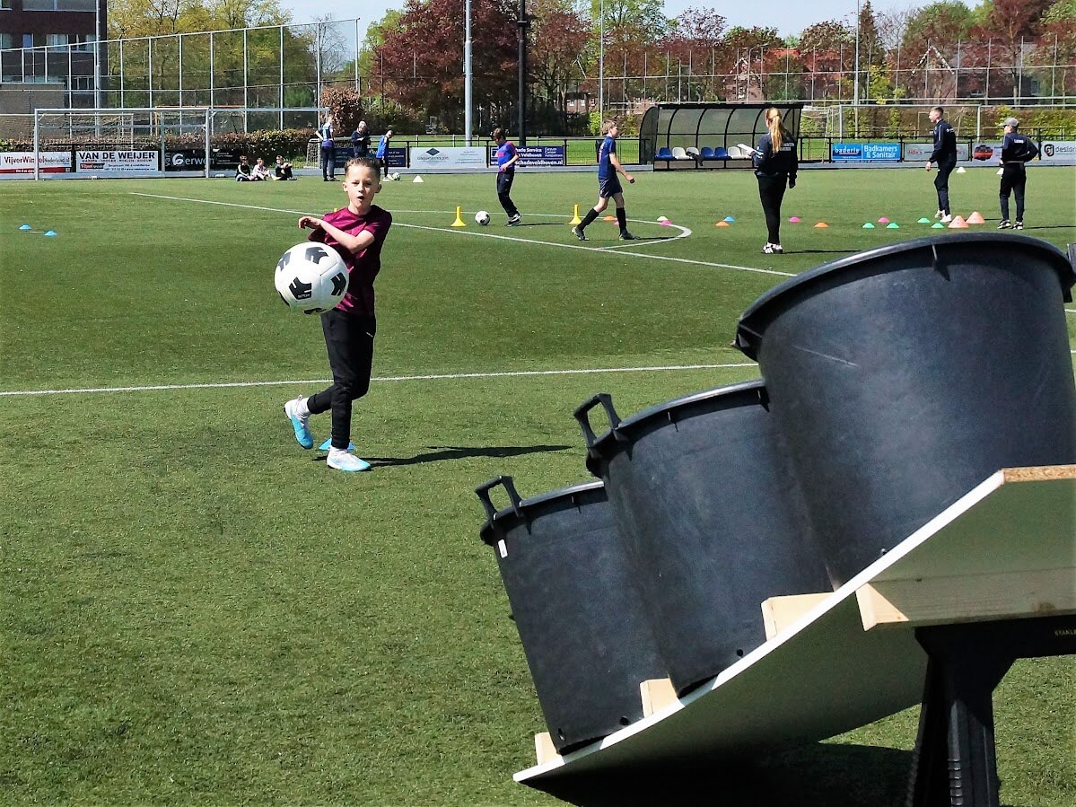 Jongen schiet bal in de lobbak tijdens skillgame standaard event van WePlay United