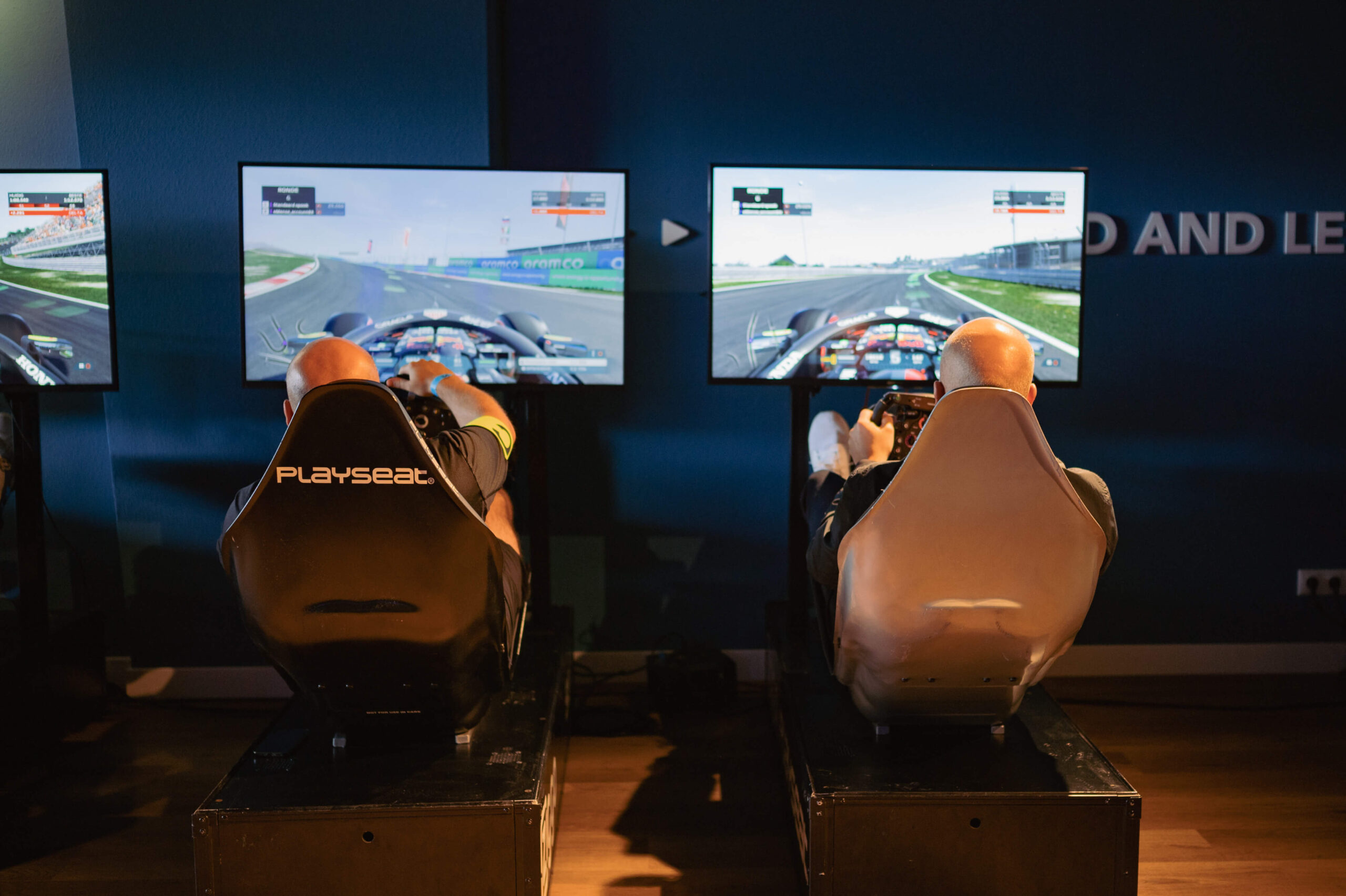 Twee mannen aan het racen op F1 simulatoren tijdens F1 uitgebreid event