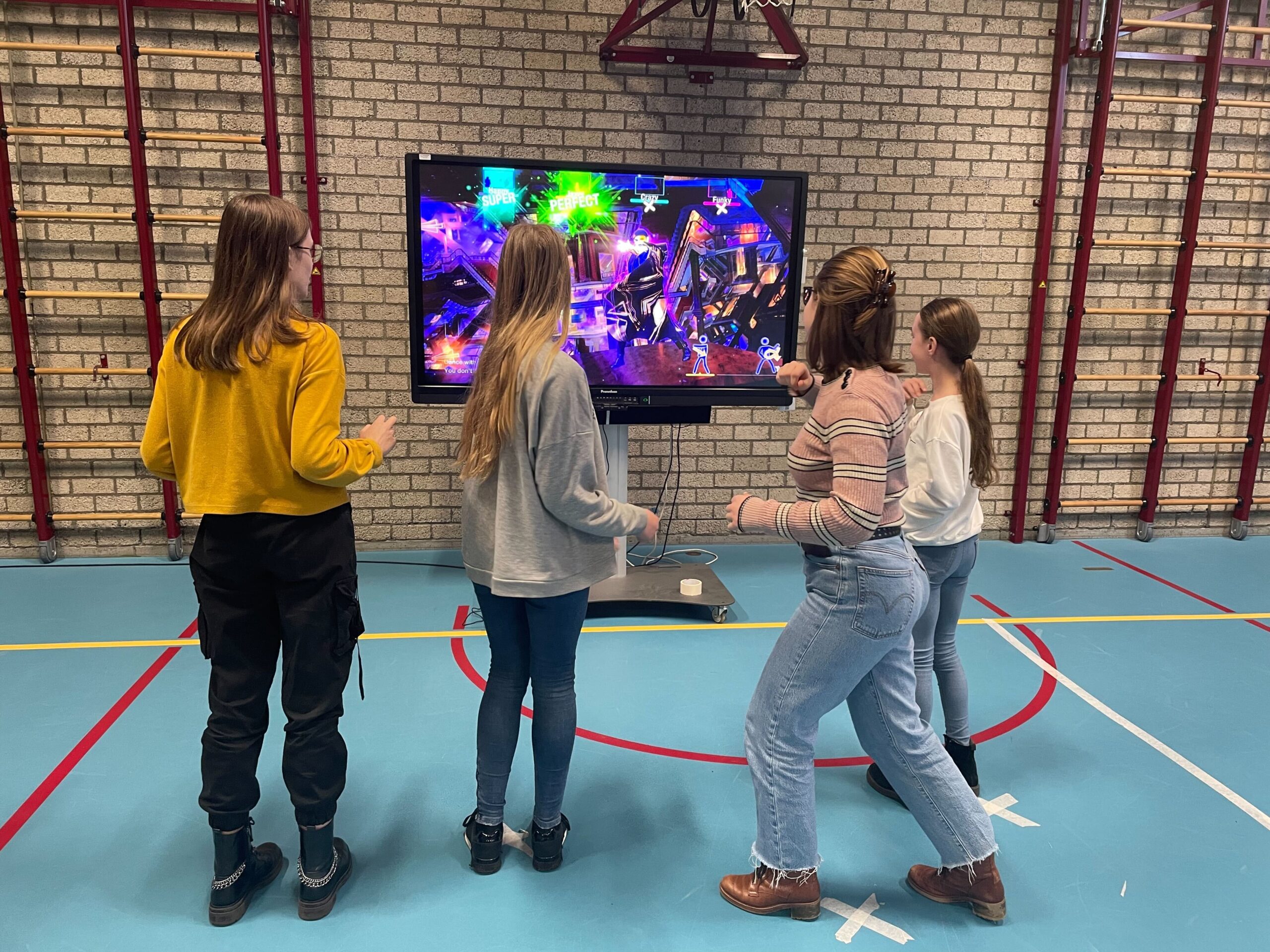 Groep meiden aan het dansen tijdens activiteitendag bij middelbare school Yuverta