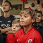 Jongen en eventmanager kijken naar deelnemers van een FIFA toernooi