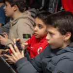 Twee jongens zijn aandachtig aan het gamen tijdens een FIFA toernooi